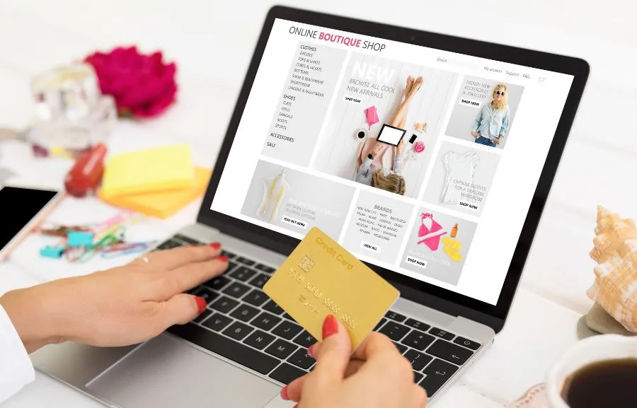A woman shopping online on her laptop with credit card.