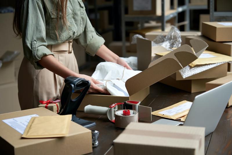 A woman warehouse employee check the delivery boxes.