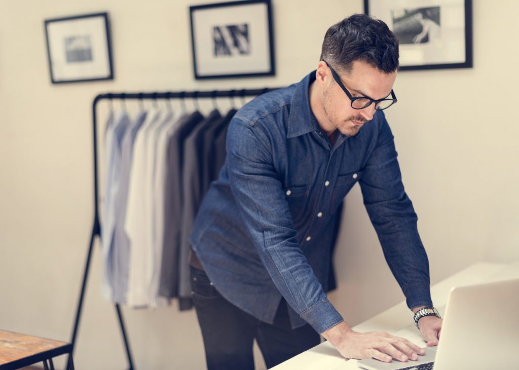 Clothing store employee checking his computer.