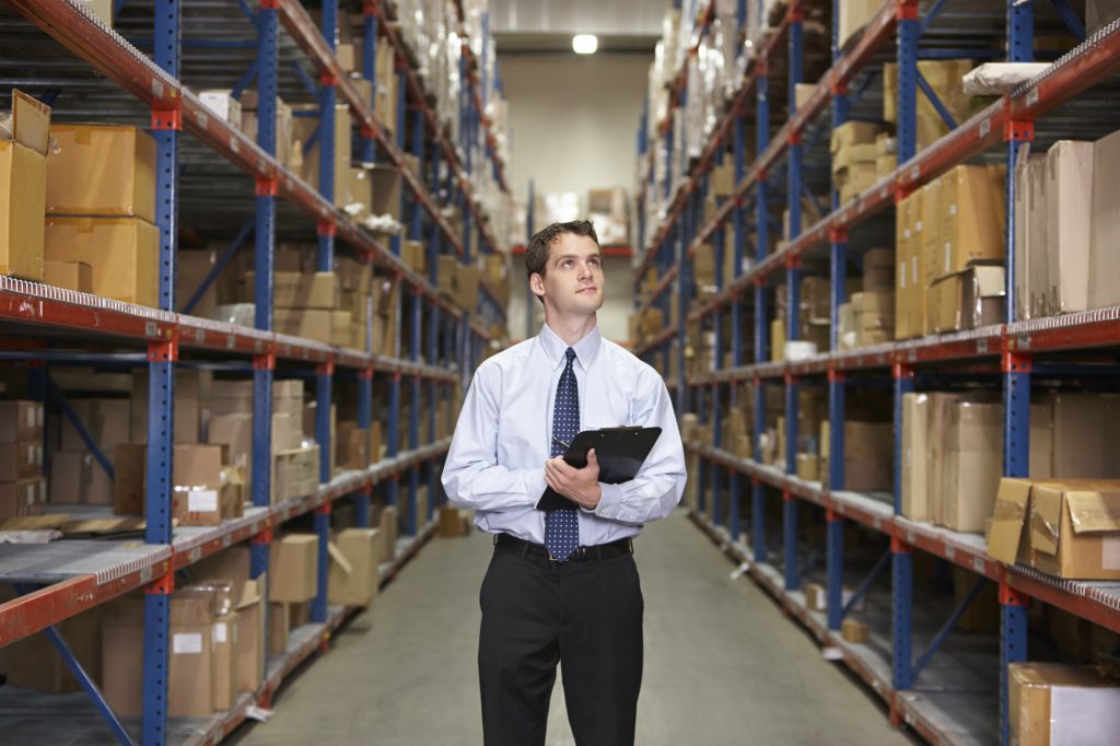 Manager In Warehouse With Clipboard